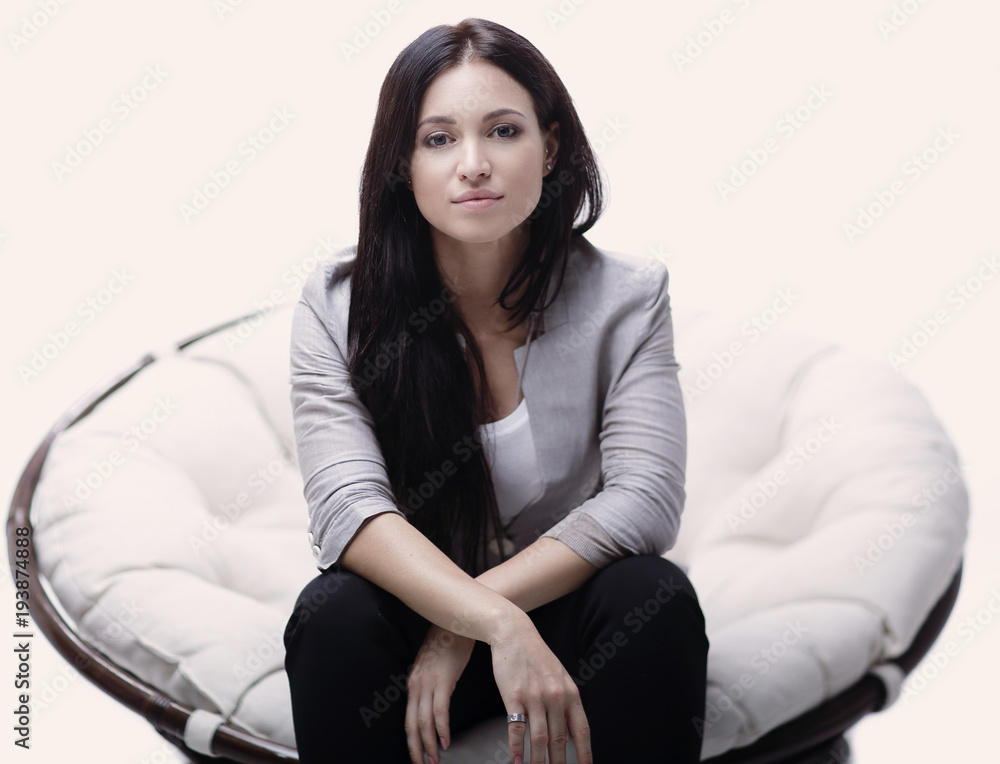 Young woman sitting in a round cozy soft big chair. Young woman sitting in a round cozy soft big chair.