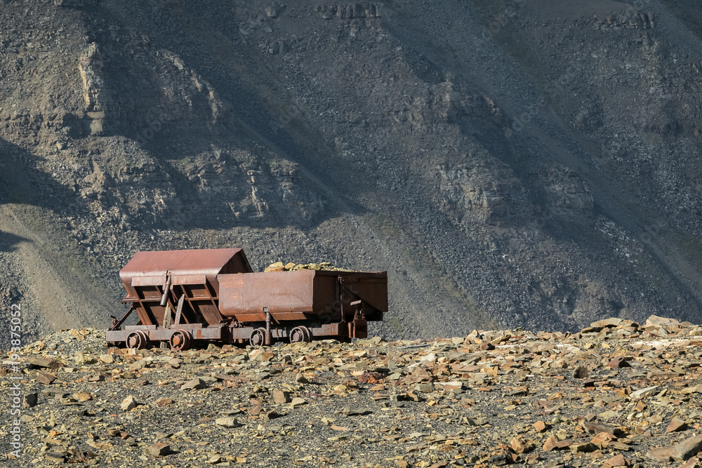 Naklejka premium Old abandoned coal wagons, used for the coal mining industry, mountain background Longyear valley, Svalbard Norway. Arctic landscape.