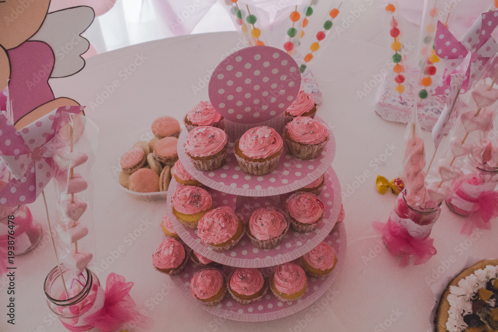 muffins de color rosa en mesa dulce con golosinas y alfajores de maicena  rosados Stock Photo | Adobe Stock