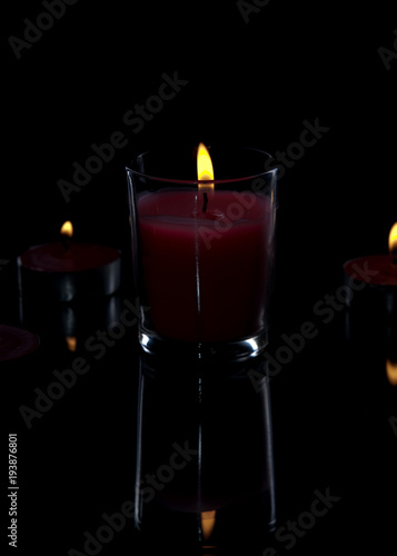 candle light with back light on a black background with reflection