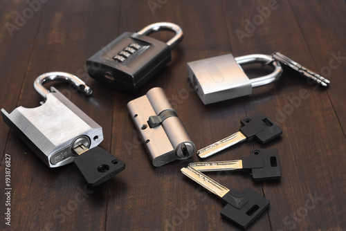 A new lock with keys on a wooden table.
