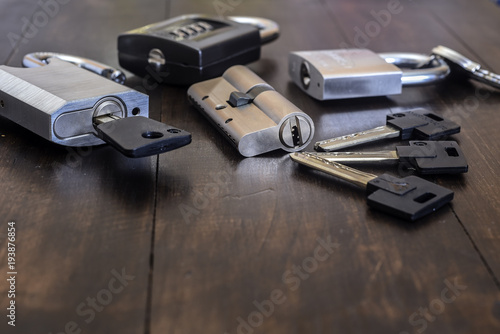 A new lock with keys on a wooden table.