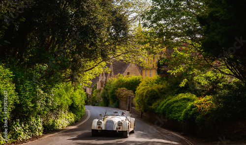 Retro vintage antique classic sport car, automobile, auto on the old english street in United Kingdom Great Britain. Motor transport for drive, travel, transportation. Vintage effect style picture.