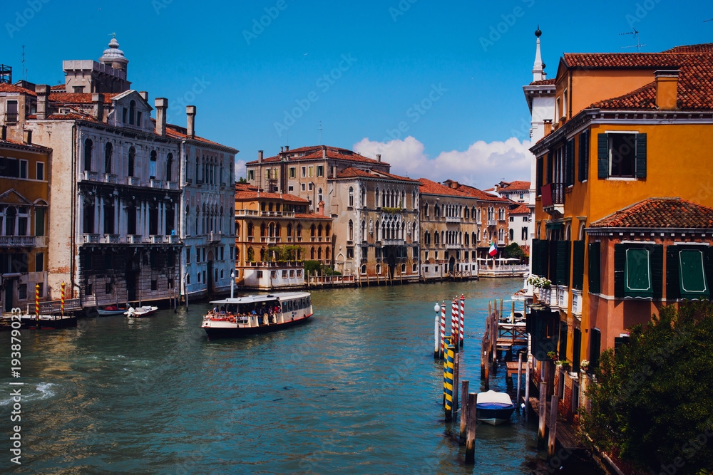Beautiful panoramic view over the famous Grand canal in Venice, surrounded by old and romantic architecture illuminated by sun, in Italy. Natural colors