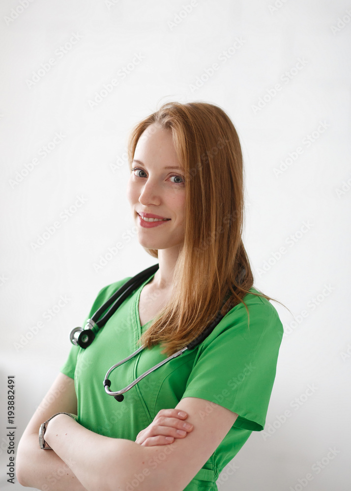 Portrait of friendly, smiling confident female doctor, healthcare professional with green lab coat. Natural light private clinic background Portrait of friendly, smiling confident female doctor, healthcare professional with green lab coat. Natural light private clinic background