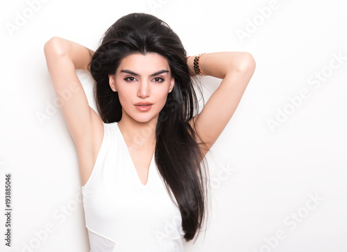 beautiful young woman with long black hair posing in white dress