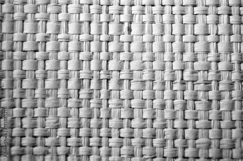 Close-up of gray plastic weave as woven background texture or pattern in black and white