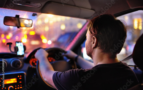 Male driver ride a car during evening traffic jam