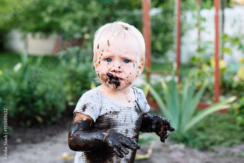 child playing in the mud on the street photo