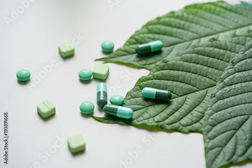 Mitragyna speciosa drug plant with pills in the laboratory research.