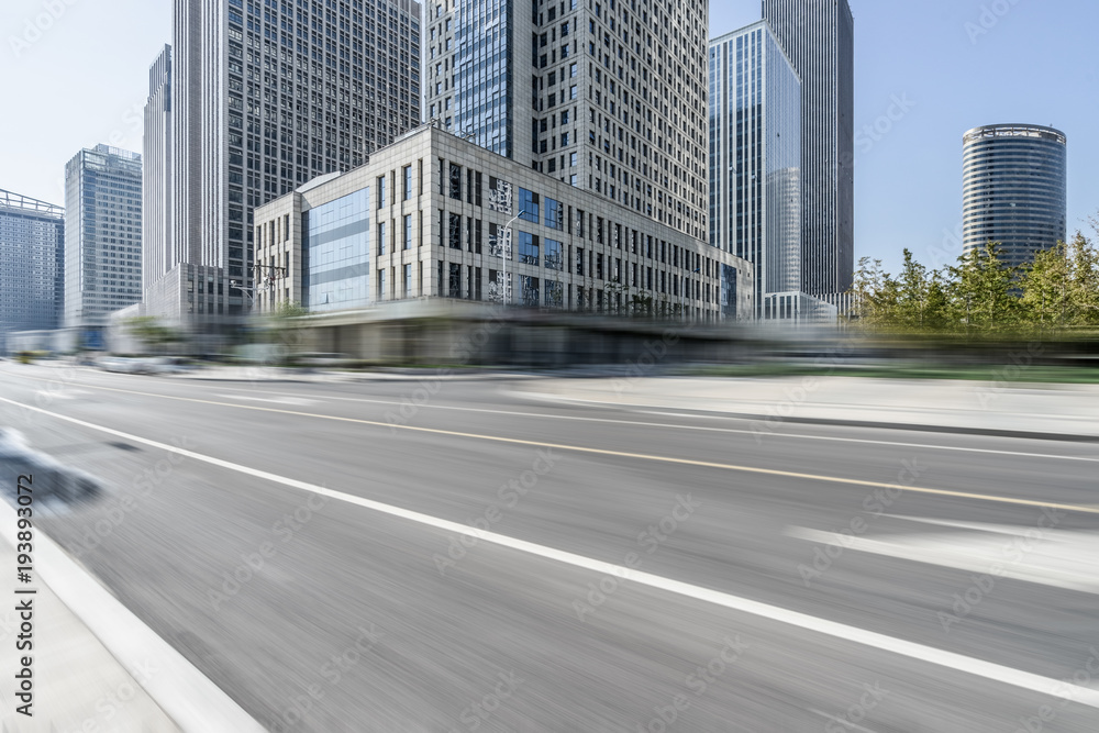 blurred asphalt road front of modern buildings