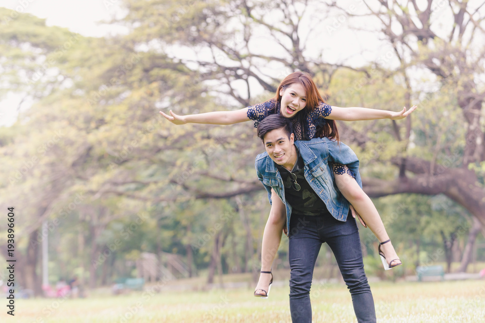 Asian couple lovers under a vast field of nature in a park. Asian couple lovers under a vast field of nature in a park.