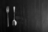 metal fork and spoon on wooden black background