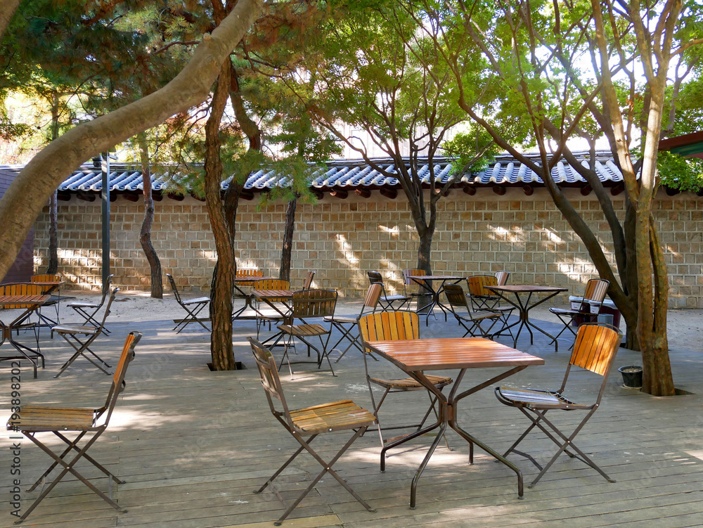 Korean outdoor cafe. Empty tables and chairs outside a traditional stone  wall in Seoul, South Korea. Stock Photo | Adobe Stock