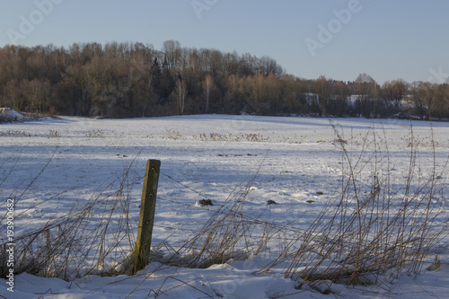 Konstfotografi wintry scene on a snowy field with a fence post