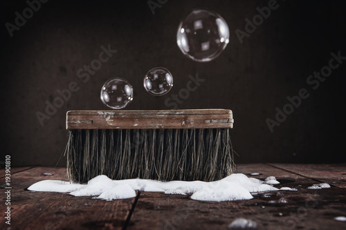 Fotografie, Obraz Old vintage scrub brush with bubbles and soap on a wooden floor