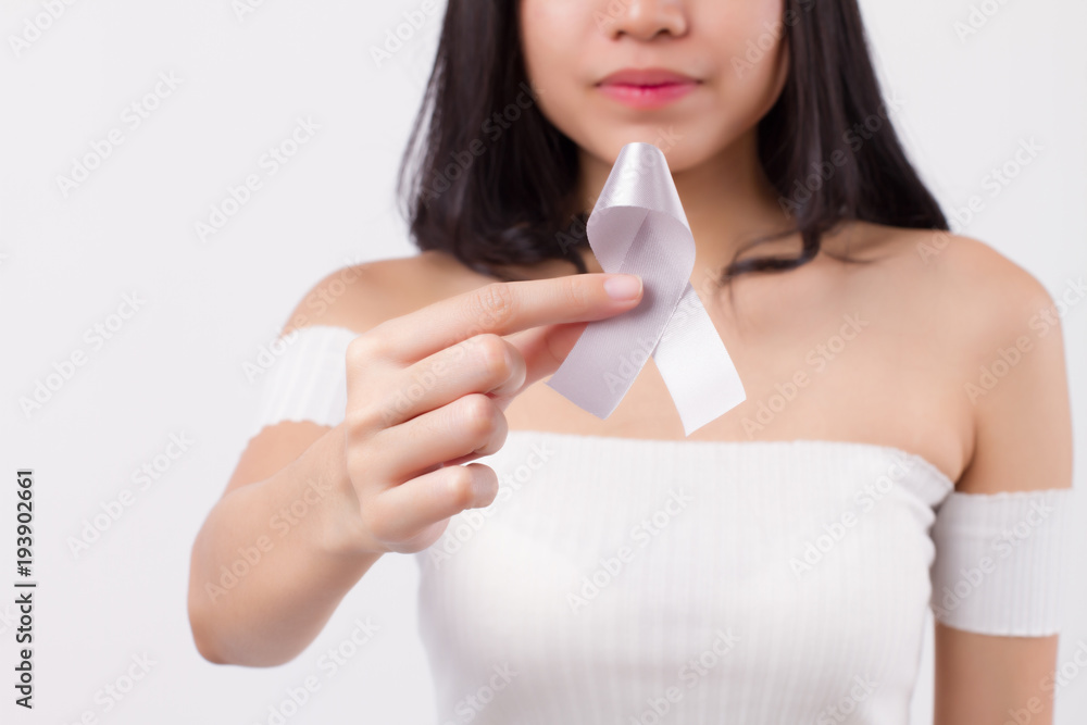 woman hand holding gray ribbon bow; brain cancer, allergy, asthma awareness symbol presented by woman in studio shot; concept for gray or grey ribbon brain cancer, allergy, asthma day awareness woman hand holding gray ribbon bow; brain cancer, allergy, asthma awareness symbol presented by woman in studio shot; concept for gray or grey ribbon brain cancer, allergy, asthma day awareness