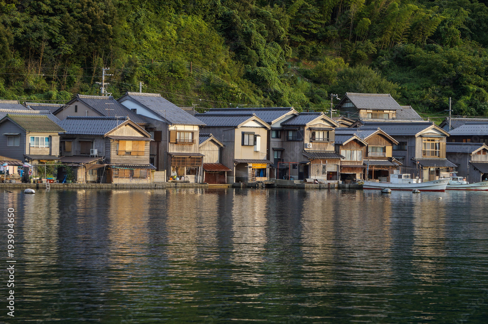 Fototapeta premium Ancient Fisherman Village on a cloudy day at Ine Boathouse of Kyoto, JAPAN.