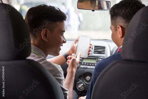 showing his mobile phone to car driver © Odua Images
