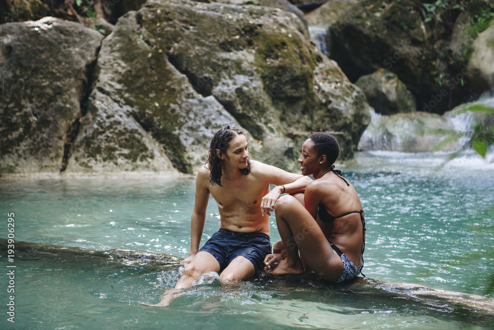 Friends hanging out by a waterfall in the jungle Friends hanging out by a waterfall in the jungle