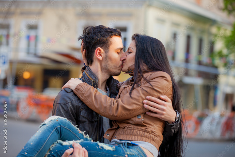 Young couple kissing on the street in springtime Young couple kissing on the street in springtime
