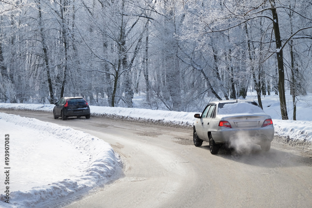 two cars driving on a curved road in winter two cars driving on a curved road in winter