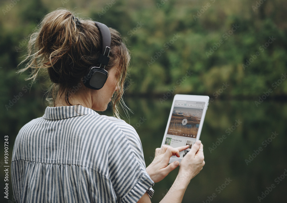Woman alone in nature listening to music with headphones - obrazy, fototapety, plakaty 