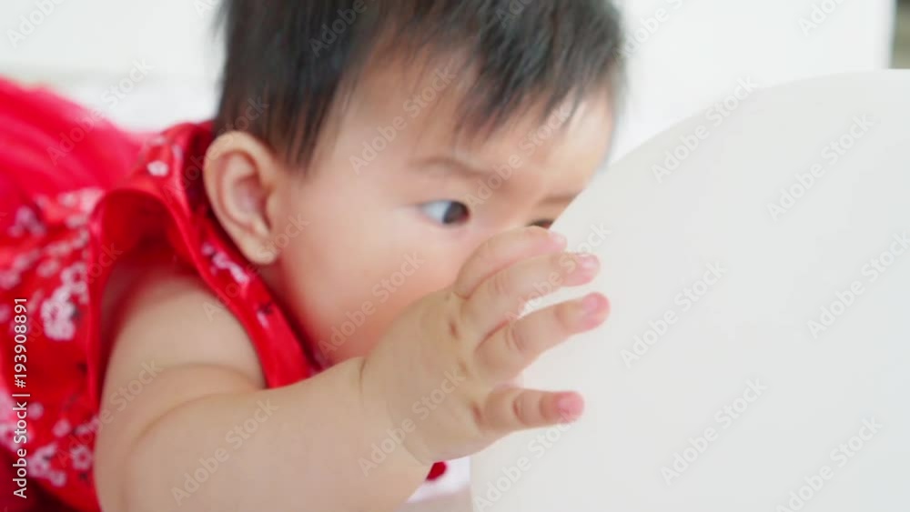 Cute asian little baby girl having fun to try to catch and play with balloon in slow motion shot Cute asian little baby girl having fun to try to catch and play with balloon in slow motion shot