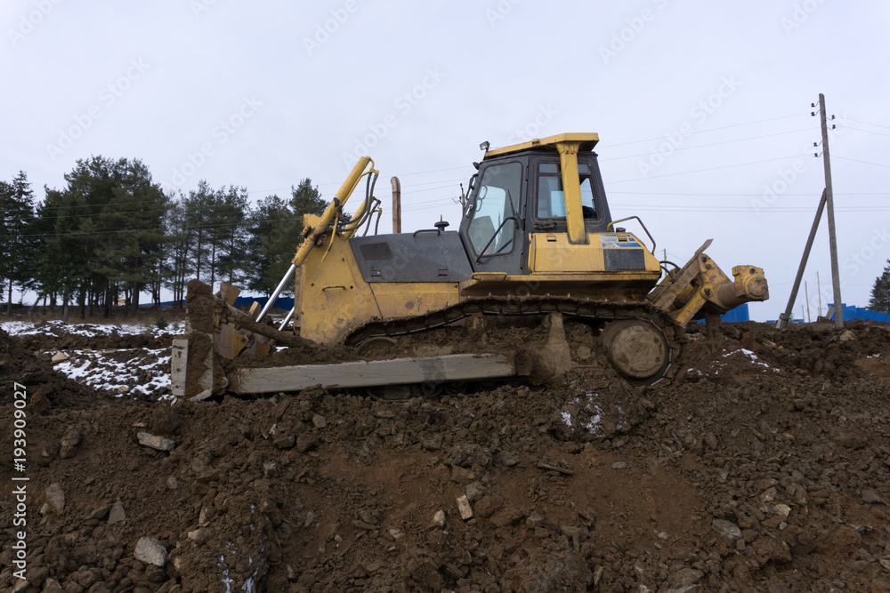 An excavator working removing earth on a construction site.