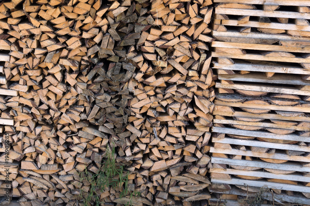 background on chopped firewood stacked in woodpile .