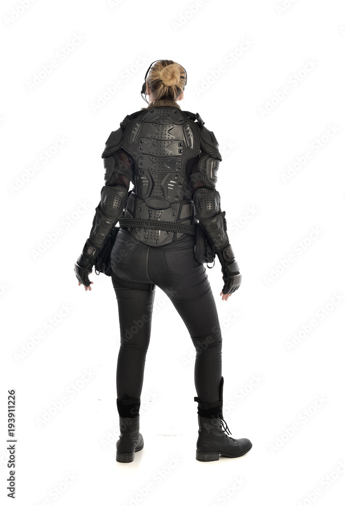 full length portrait of female  soldier wearing black  tactical armour  facing away from camera, isolated on white studio background.