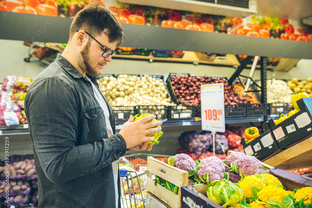 man seek vegetables in supermarket