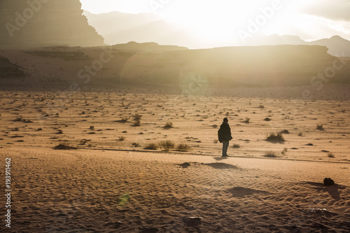 Silhouette of a girl who watches the sunset in desert in Jordan