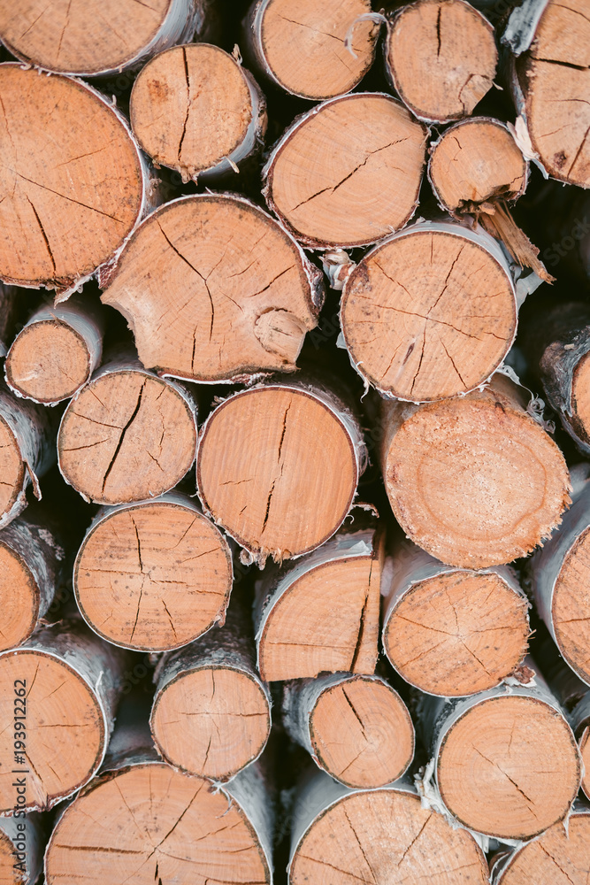 Fototapeta premium Wooden background - closeup. Firewood for the winter, stacks of firewood, pile of firewood. Firewood prepared for winter.