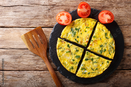 Egyptian food: omelet Igga with greens and onions close-up. Horizontal top view photo