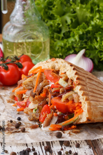 A dish of pita bread stuffed with grilled meat, then chopped meat and fresh vegetables. photo