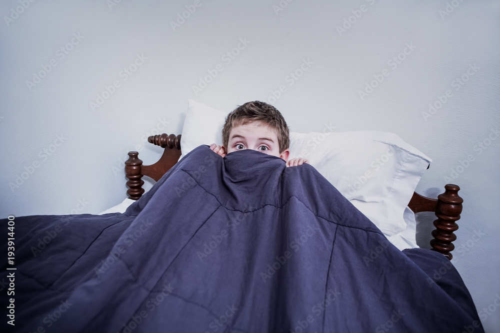 Boy hiding in bed under the covers Stock Photo | Adobe Stock