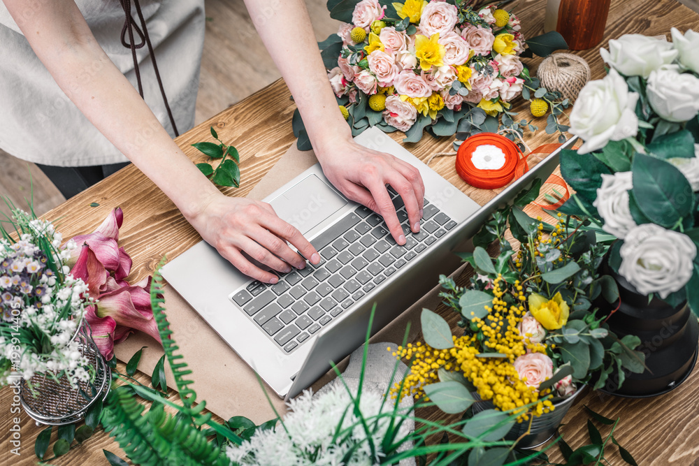 Florist working with laptop in a flower shop Stock Photo | Adobe Stock