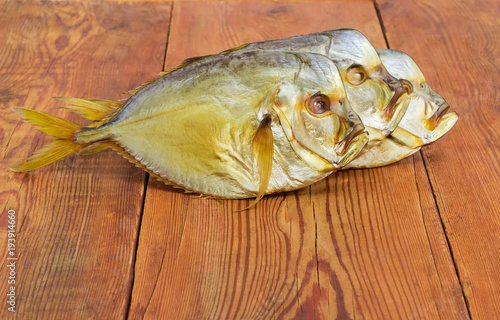 Three smoked Atlantic moonfish on the rustic wooden table photo