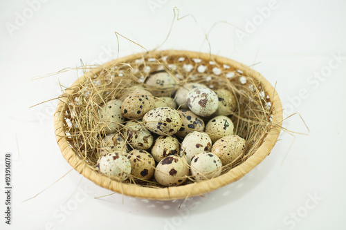 Quail eggs in a basket on a rustic wooden background. Healthy food concept.