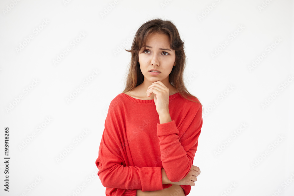 Picture of upset brunette student girl of mixed race appearance having worried look, holding hand on her chin, feeling nervous before exams at college. Stress, anxiety, worry and emotions concept Picture of upset brunette student girl of mixed race appearance having worried look, holding hand on her chin, feeling nervous before exams at college. Stress, anxiety, worry and emotions concept