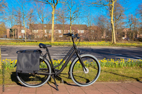 The bicycle stands on a bicycle path near the highway.