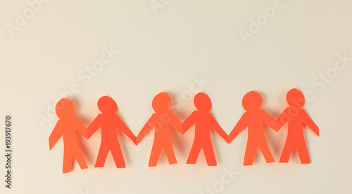 four paper men taking each other's hands