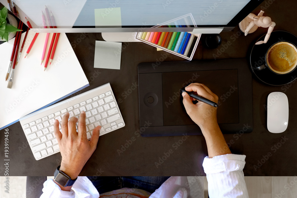 Top view Designer working with digital tablet and desktop computer at dark desk - obrazy, fototapety, plakaty 