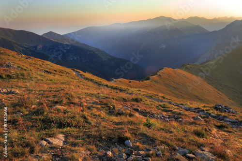 Poland, Tatra Mountains, Zakopane - trail to Czerwone Wierchy peaks at sunset with Western Tatra mountain range panorama in background