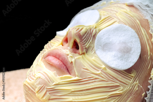 Spa concept. Young woman with nutrient facial mask in beauty salon