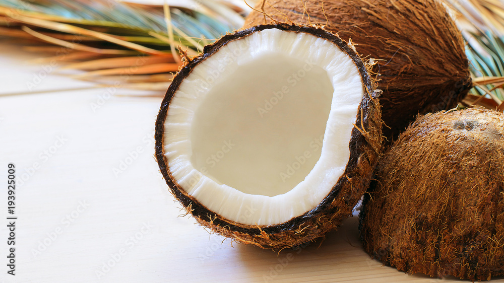 Close up of coconut with palm leaf on wooden background. Copy space. Close up of coconut with palm leaf on wooden background. Copy space.
