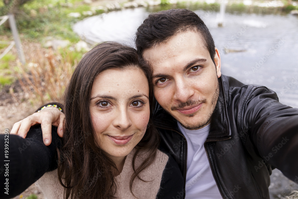 nice couple boyfriends in the park takes a selfie nice couple boyfriends in the park takes a selfie
