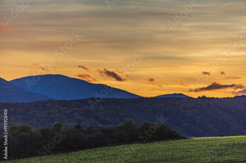 beautiful sunset landscape over the green hills  © babaroga