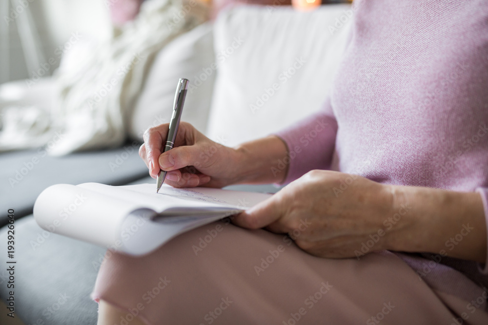 Senior lady holding notepad taking notes Senior lady holding notepad taking notes